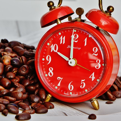 Orange clock and coffee beans. Photo credits Pixabay.